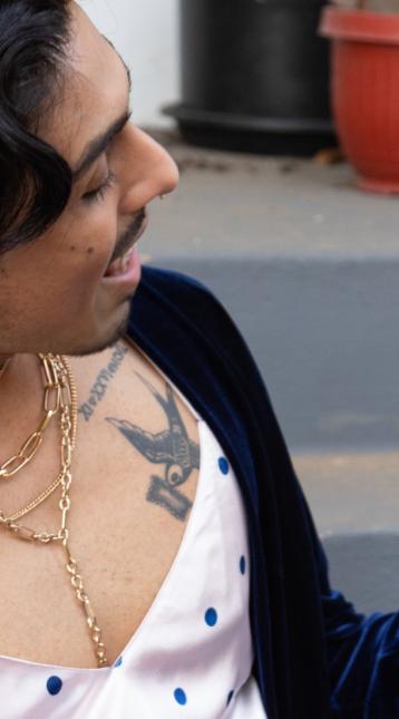 Happy stylish latino queer person looking comfortable on porch steps
