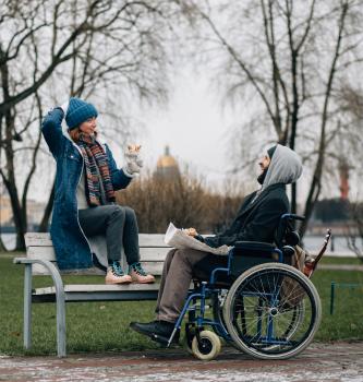 Two young women sit in seats looking out the window of a moving ferry.